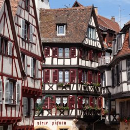 Casas de entramado de madera y colores junto a un canal florido en Colmar, Alsacia