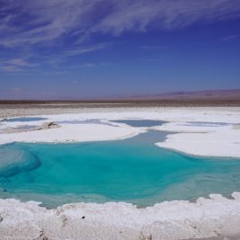 Laguna altiplánica turquesa con volcanes al fondo en el desierto de Atacama