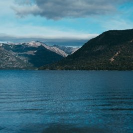 Vista del lago Nahuel Huapi con bosques y montañas nevadas cerca de Bariloche