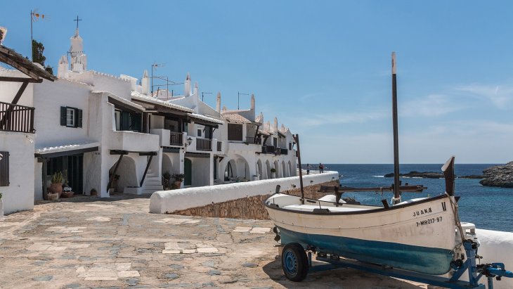 Callejuelas blancas y casas encaladas de Binibeca Vell, el pueblo de pescadores de Menorca, junto al mar Mediterráneo