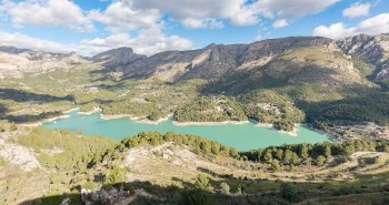 Vista panorámica del Castell de Guadalest con el campanario blanco sobre la peña y el embalse turquesa al fondo