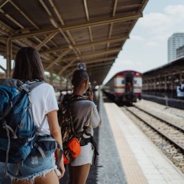 Jóvenes con mochilas esperando un tren en una estación europea