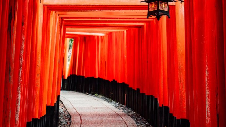 Viajero caminando entre los torii rojos del santuario Fushimi Inari en Kioto