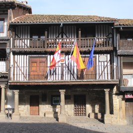 Calle empedrada de La Alberca con casas serranas de entramado de madera y balcones con flores