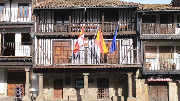 Calle empedrada de La Alberca con casas serranas de entramado de madera y balcones con flores