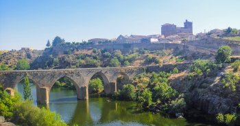 Vista de Ledesma amurallada sobre el río Tormes con el puente viejo en primer término