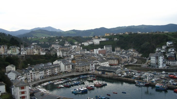 Vista panorámica de las casas blancas de Luarca alrededor de su puerto pesquero al atardecer