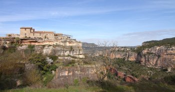 Vista de Siurana en lo alto de su risco calizo con el embalse turquesa al fondo