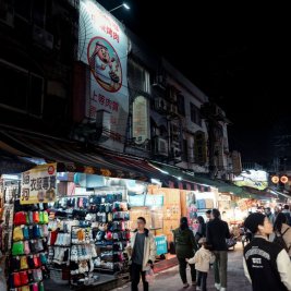 Mercado nocturno de Taipéi lleno de puestos de comida y letreros luminosos