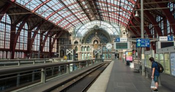 Interior monumental de una estación de tren histórica con gran cúpula y escalinatas