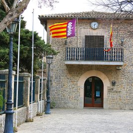Vista panorámica de Valldemossa con la torre de la Cartuja entre casas de piedra y las montañas de la Serra de Tramuntana al fondo