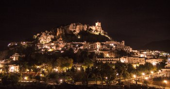 Vista de Zahara de la Sierra con el torreón del castillo en lo alto del cerro y el embalse turquesa a sus pies