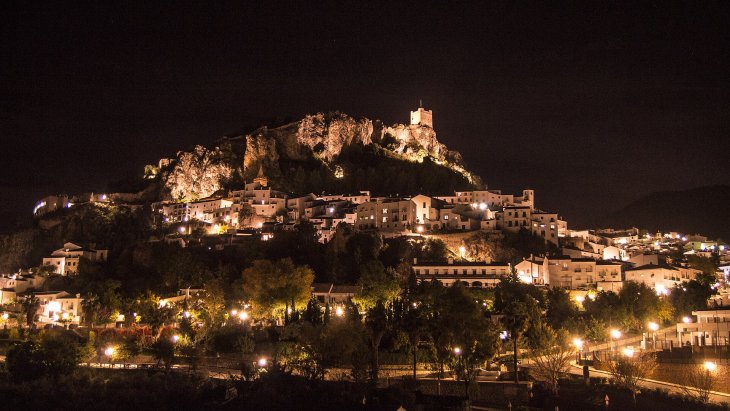 Vista de Zahara de la Sierra con el torreón del castillo en lo alto del cerro y el embalse turquesa a sus pies